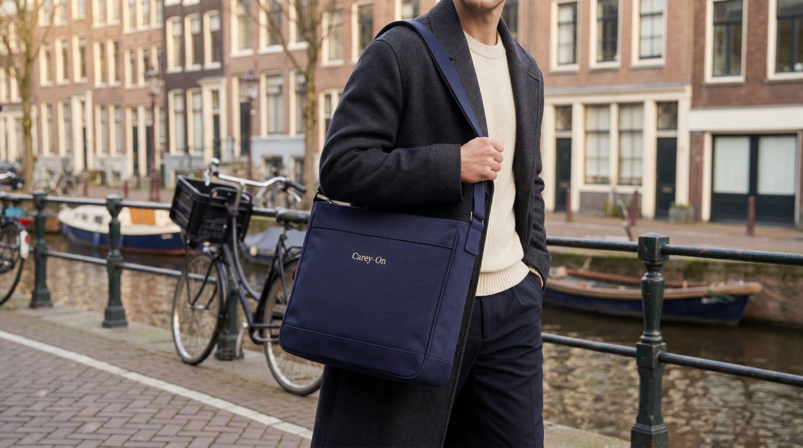 A person carrying the navy Crossbody along an Amsterdam canal
